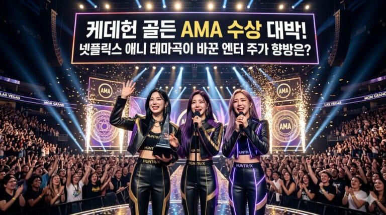 화려한 미국 아메리칸 뮤직 어워즈(AMA) 시상식 무대 위에서 넷플릭스 애니메이션 케이팝 데몬 헌터스의 가상의 K팝 걸그룹 헌트릭스 멤버 3명이 트로피를 들고 환하게 웃으며 수상 소감을 전하는 실사 스타일의 장면. 상단 전광판에는 '케데헌 골든 AMA 수상 대박! 넷플릭스 애니 테마곡이 바꾼 엔터 주가 향방은?'이라는 문구가 한국어로 명확하게 적혀 있으며, 무대 아래에는 수많은 관객들이 환호하고 있다
